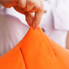Giant carrot plush toy being squeezed by a hand; ultra-soft, hypoallergenic fabric for kids.