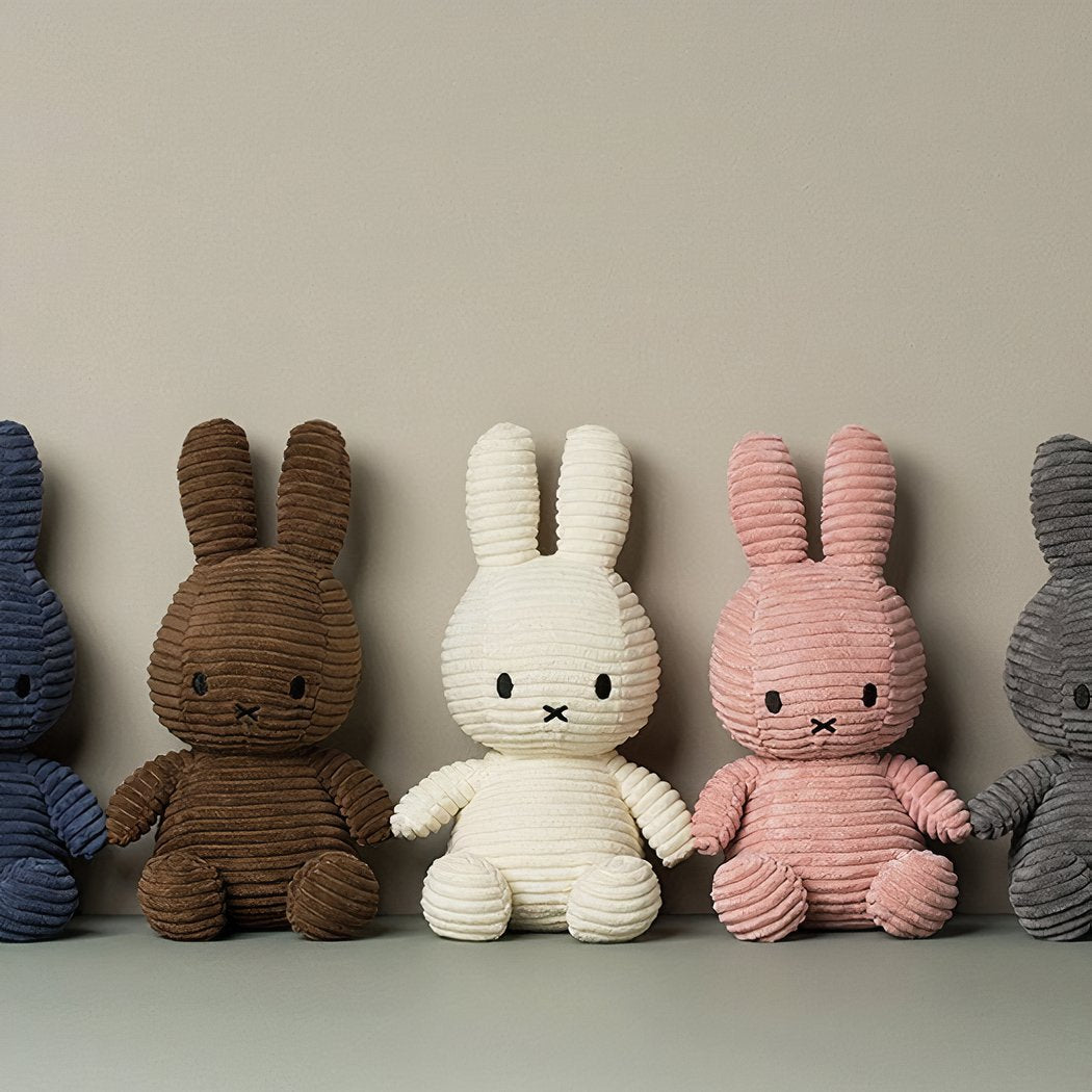 Peluche Miffy côtelé Bleu among corduroy bunny plush toys in blue, brown, white, pink and grey.