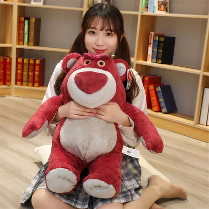 Young woman sitting on the floor, hugging a giant Lotso Toy Story plush bear