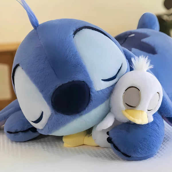 Peluche Stitch allongée avec son canard