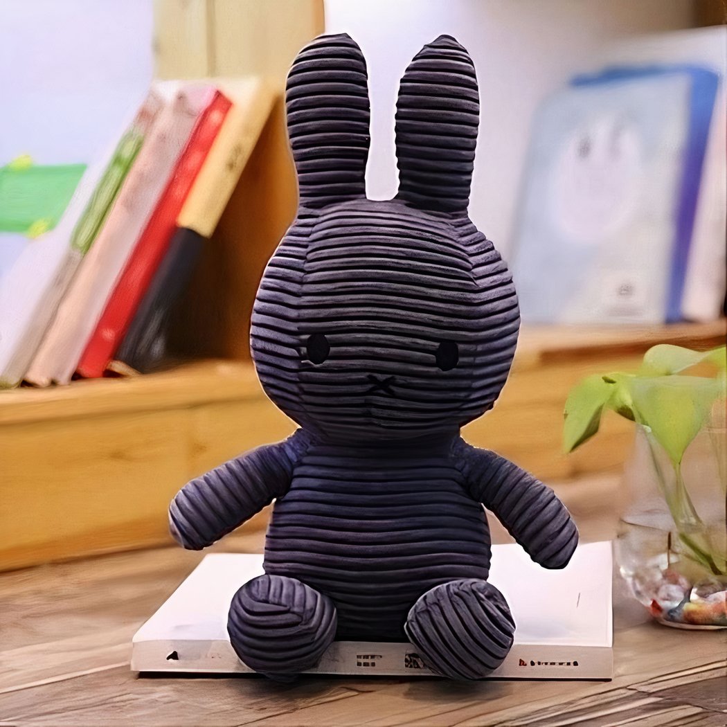 Peluche Miffy côtelé Bleu plush with navy corduroy texture, seated on a shelf.