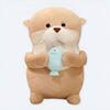 Soft otter plush holding a light blue fish