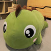 Green kawaii dinosaur plush toy with oversized eyes and brown spikes on the floor.